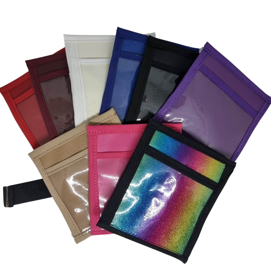 A collection of Flip Over Arm Bands in various solid colors and one with a multicolored reflective surface, designed to hold numbers for dog shows or training events.